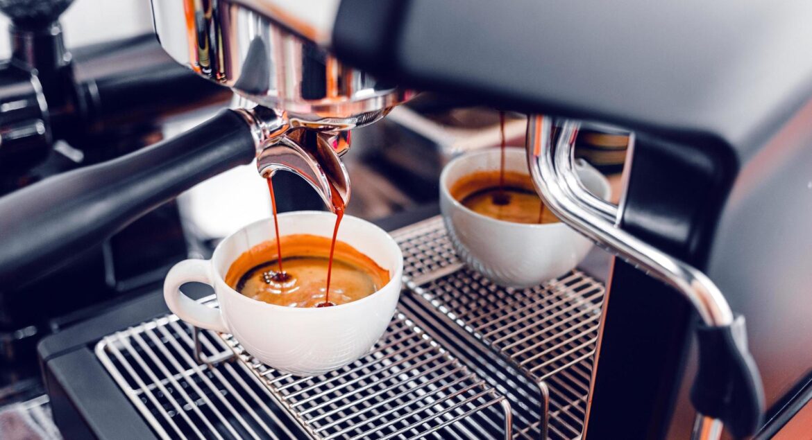 coffee-extraction-from-the-coffee-machine-with-a-portafilter-pouring-coffee-into-a-cup-espresso-pouring-from-coffee-machine-at-the-coffee-shop-free-photo